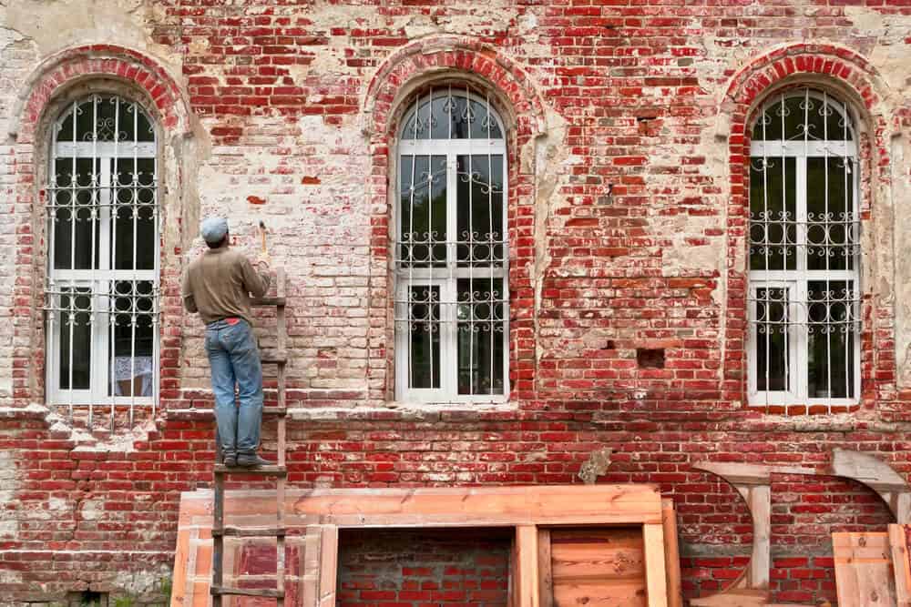 worker working on a red brick fassade