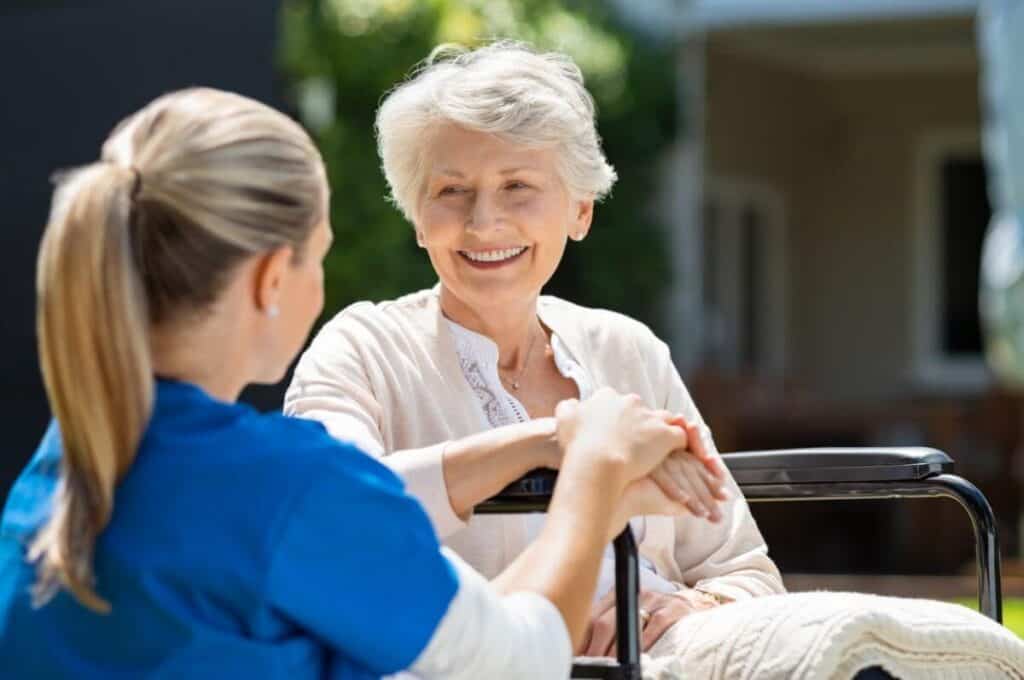 elderly woman smiling to a nurse