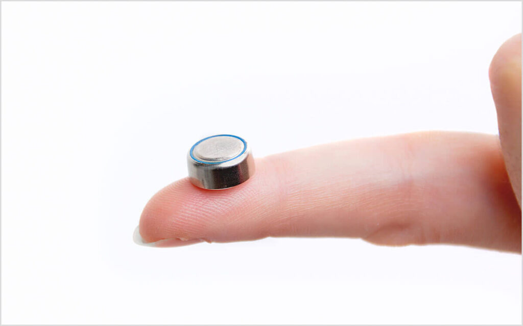 hearing aid battery on index finger tip