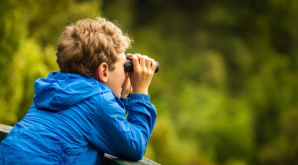 boy with binoculars bird watching