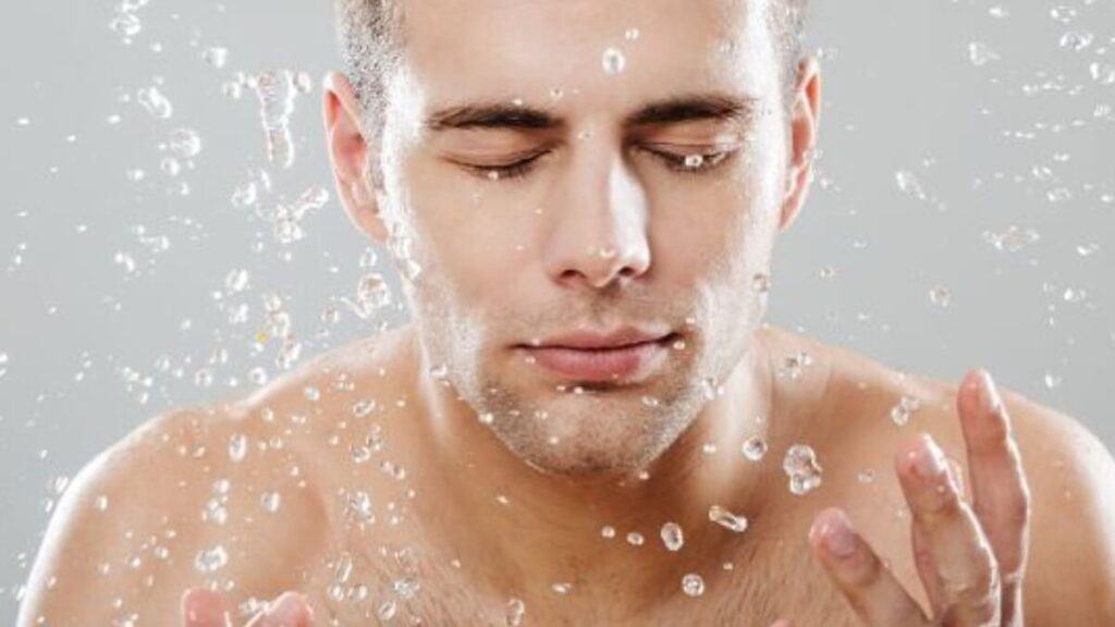 man splashing water on his healthy skin